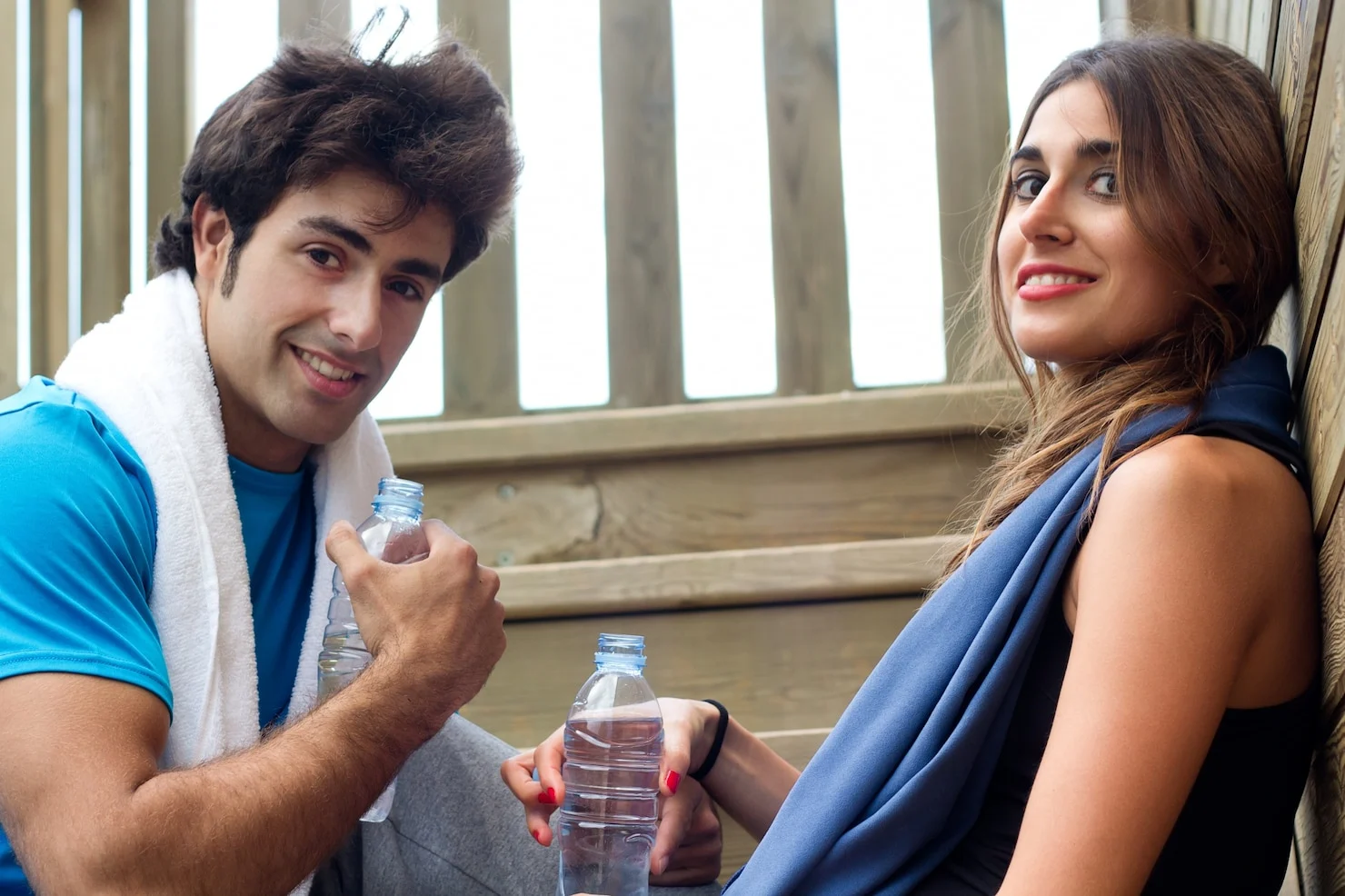 Two people hydrating after a fitness workout