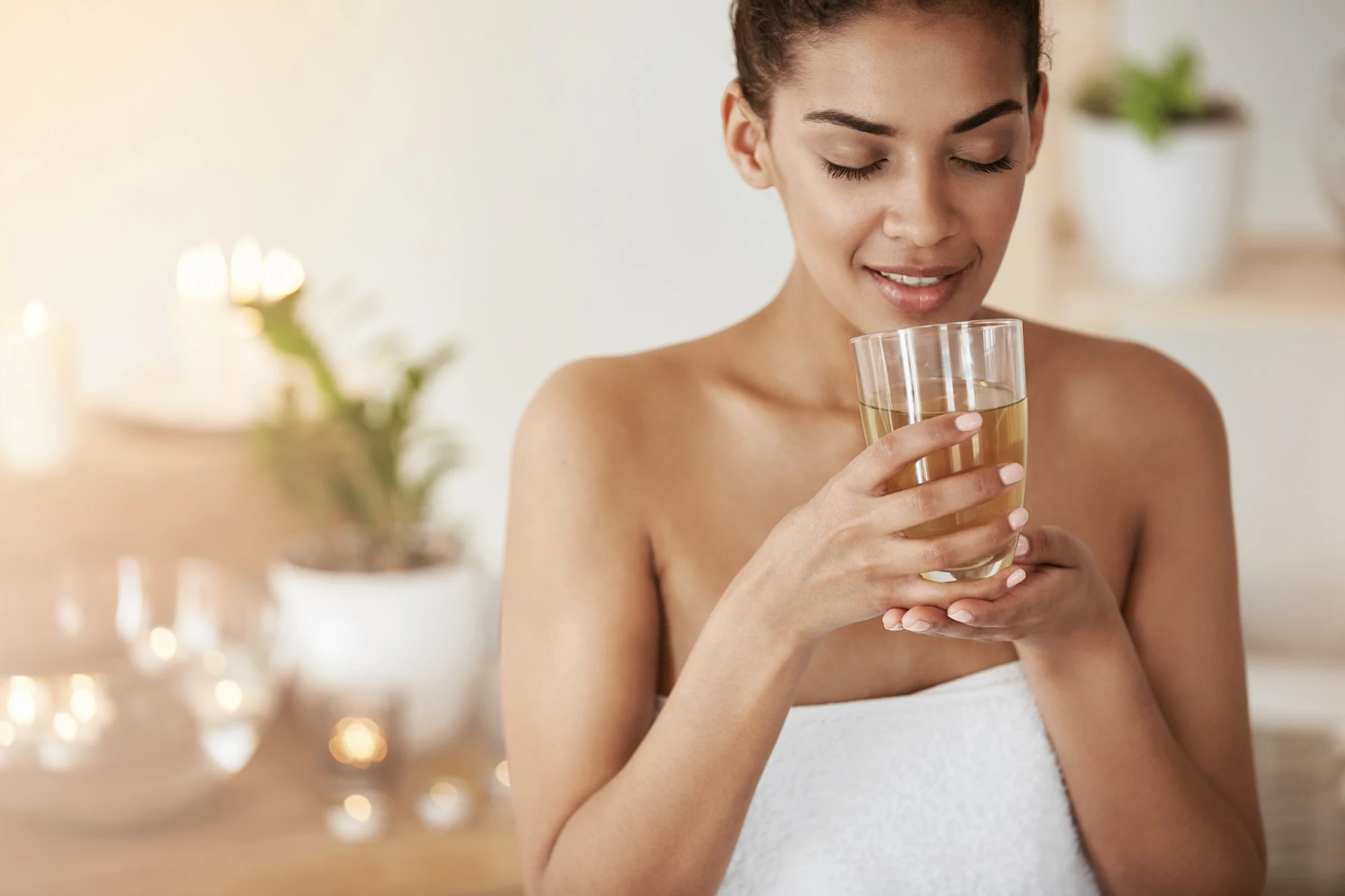 Relaxed woman holding a glass during a wellness routine
